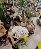 Florista de Arrels de la Vila con un gran ramo de margaritas en el taller